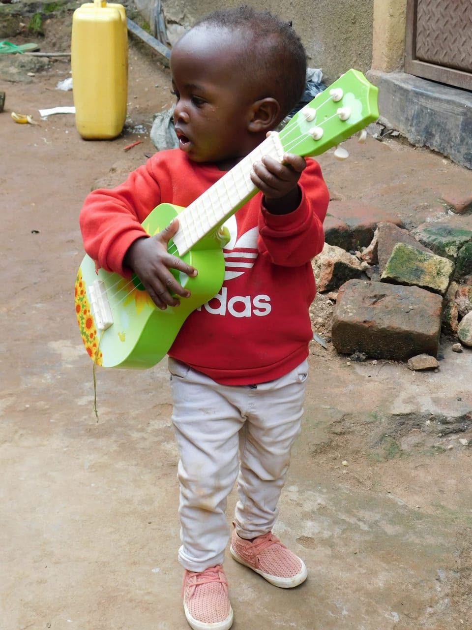 Young Prince with a toy green guitar outdoors